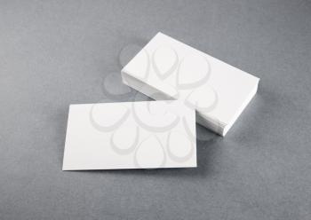 Photo of blank business cards with soft shadows on gray background. Mock-up for branding identity. Studio shot.