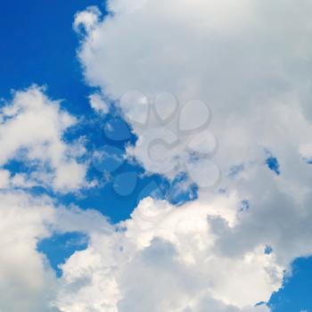 Cumulus clouds against a bright blue sky.