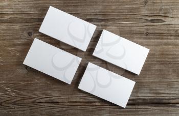 Photo of blank business cards on a dark wooden background. Template for branding identity. Top view.