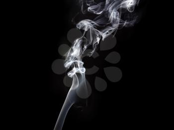 Photo of abstract smoke swirls on dark background. Studio shot.