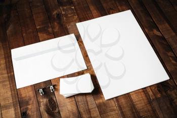 Blank letterhead, business cards and envelope. Photo of blank stationery set on vintage wooden table background. Mockup for design portfolios. Blank template for branding identity.