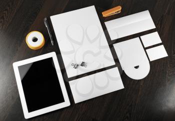 Blank stationery and corporate identity template on dark wooden background.  For design presentations and portfolios.