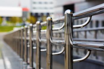 Chromium metal fence with handrail. Chrome-plated metal railings. Shallow depth of field. Selective focus.