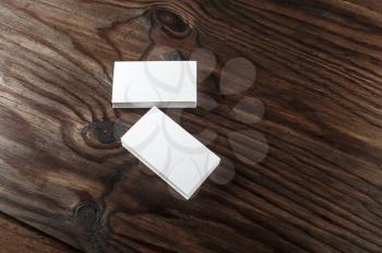 Blank white business cards on a dark wooden background. Mock-up for branding identity. Blank template for graphic designers portfolios.