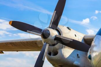 Engine and propeller of an old vintage airplane on a blue sky background. Selective focus on propeller.