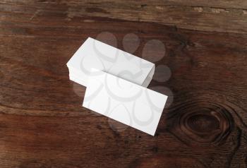 Photo of blank business cards on dark brown wooden background. Blank template for design presentations and portfolios.