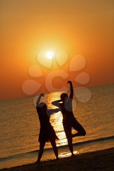 Two girls dancing on the background of the dawn. Shallow depth of field.