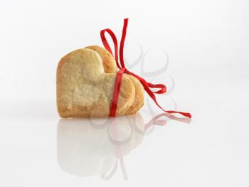 Festive cookies in the shape of hearts, tied with a red ribbon with a bow.