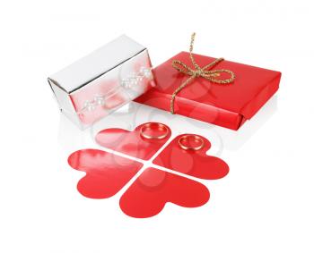 Gift box with red paper hearts and wedding rings on a white background. Isolated with clipping path.