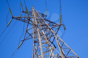 High voltage tower against the blue sky. Electricity transmission pylon