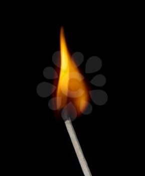 Build a fire. Lighted match on a black background