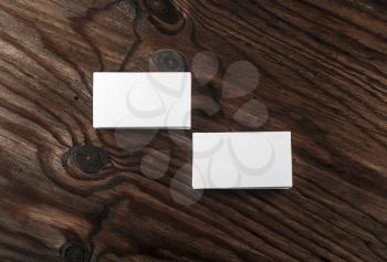 Photo of blank white business cards on dark wooden background. Mock-up for branding identity. Top view.