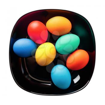 Easter eggs on a black plate on white background. Isolated with clipping path. Top view.