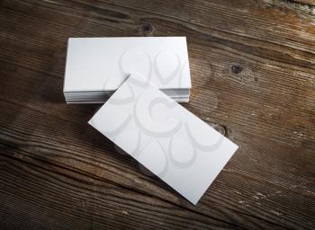 Blank white business cards on a dark wooden background. Mockup for branding identity. Blank template for design presentations and portfolios. 