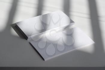 Photo of blank business cards on light background. The shadow of the blinds. For design presentations and portfolios.