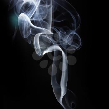 Abstract smoke swirls over black background. Studio shot.
