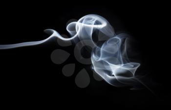 Photo of abstract smoke swirls over black background.