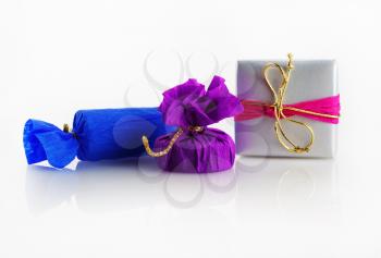 Bright colorful gift boxes with decorative ribbons and bows on a light background.