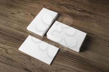 Mockup of three blank business cards stacks on wood table background. Blank template for your design.