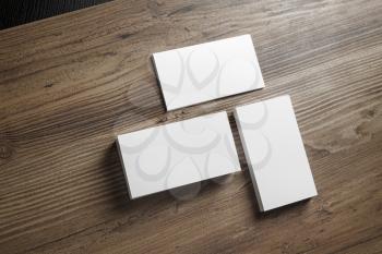 Three piles of blank business cards on wood table background. Mock-up for branding identity for designers. Blank template for your design.