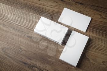 Photo of blank business cards on wooden office table background. Presentation template for branding identity. Top view.