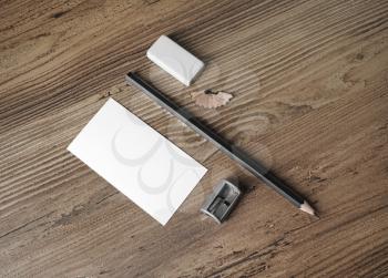 Blank stationery elements. Mockup for placing your design. Bank business card, pencil, eraser and sharpener on wood table background. Top view.