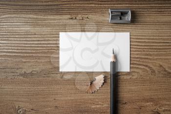 Photo of blank business card, pencil and sharpener on wooden table background. Responsive design mockup. Top view.