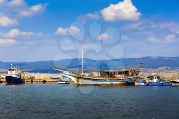 Nesebar, Bulgaria - August 30, 2013: Old rusty ship, boats and yachts at the pier in the port of the old town of Nessebar, on the Black Sea coast. Sunny day.