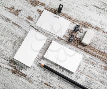 Photo of blank corporate identity. Stationery set. Business cards, badge, pencil and eraser on vintage wood table background. Branding mockup. Top view.