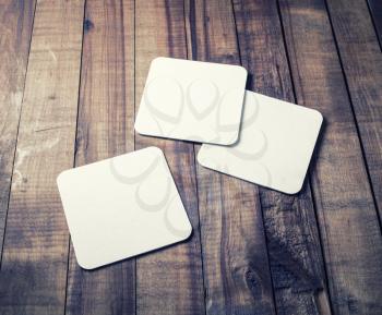 Photo of three blank beer coasters on vintage wood table background. Blank template for your design.