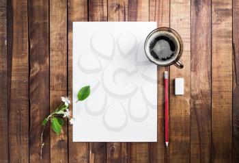 Blank sheet of paper, coffee cup, pencil and eraser on wood background with plenty of copy space. Blank template for placing your design. Responsive design mockup.