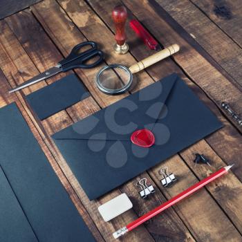 Photo of vintage blank black stationery elements on old wood table background. Branding template. Mock-up for your design.