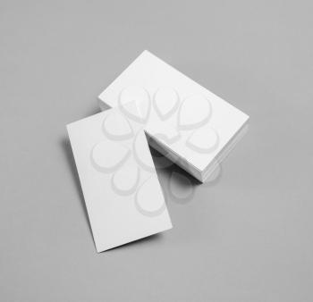 Photo of blank white business cards on gray paper background. Mockup for branding identity.