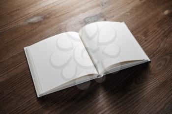 Photo of blank book mockup on wood table background. Responsive design template.