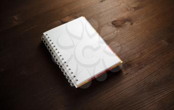 Blank notebook or notepad on wooden background. Template for placing your design.