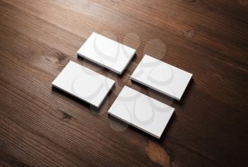 Four blank white business cards stacks on wooden background. Template for ID.