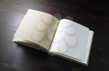 Open blank book on wood table background. Template for placing your design.