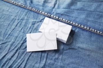 Blank business cards on denim background. Mockup for branding identity.