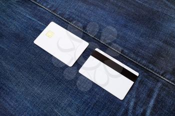 White plastic credit cards on denim background. Front and back view.