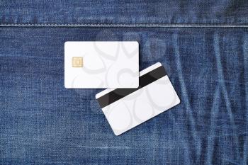 Bank white plastic chip cards on denim background. Two credit cards. Front and back view. Flat lay.