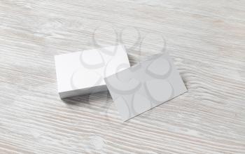 Blank white business cards on light wooden background. Mockup for branding identity. Template for graphic designers portfolios.