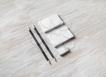 Photo of blank business cards, pencils and eraser on light wooden background. Branding mockup.