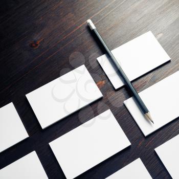 Photo of blank white business cards and pencil on wooden background. Copy space for placing your design.