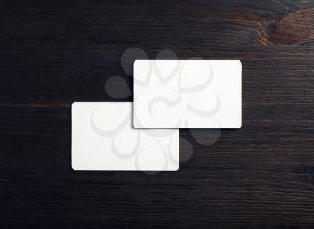 Two blank white business cards on wood table background. Mockup for branding ID. Flat lay.