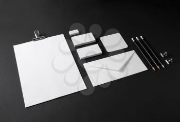 Photo of blank stationery set on black paper background. Mock up for branding identity. ID template.