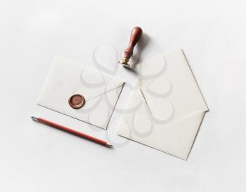 Envelope, seal, stamp and pencil on paper background. Responsive design mockup. Blank stationery. Top view.