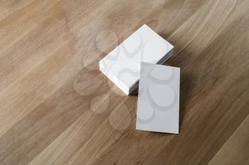Mockup of blank business cards on wooden background.