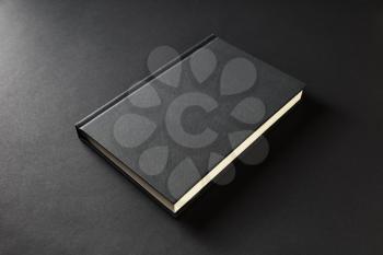 Blank book cover on black paper background.
