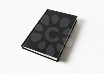 Mockup of closed blank black book at white paper background.