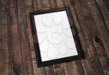 Blank photo frame on wooden background. Responsive design mockup.